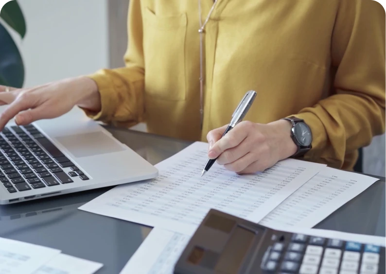 Person working on laptop and documents